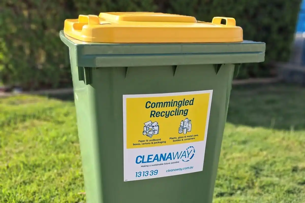 Yellow-lid recycling bin with a yellow sticker highlighting acceptable materials